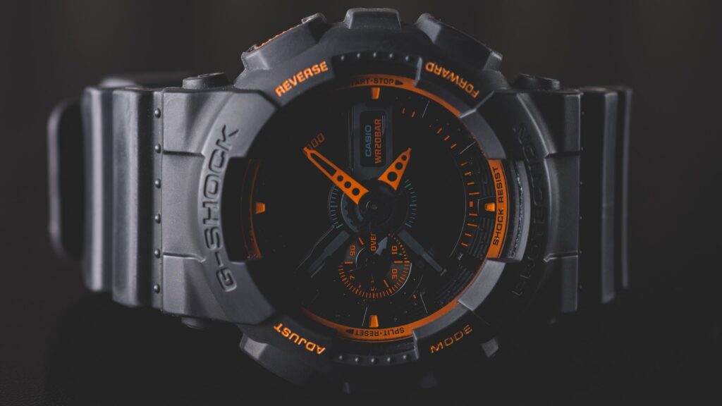 Reloj analógico negro con las agujas naranja, serie G-Shock de Casio.